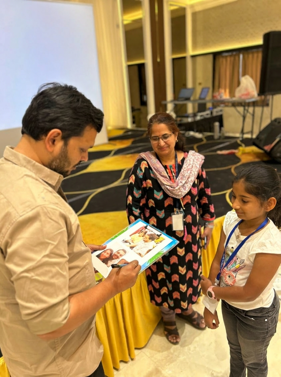 A signed keepsake moment between Sajan Shah, a child, and parent
